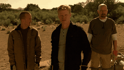 three men standing in a desert with one wearing a t-shirt that says ' abercrombie & fitch ' on it