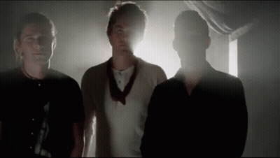 Three Men Standing In Dark Room GIF