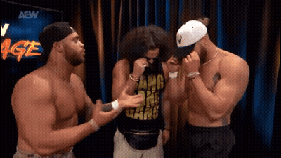 Three Men Standing In Front Of AEW Sign GIF