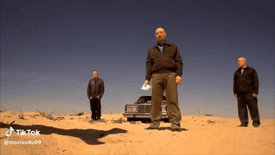 Three Men Standing In Sand In Front Of Car In Desert GIF