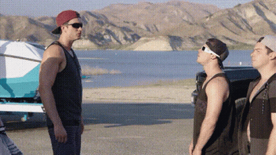 Three Men Standing Next To Each Other On A Beach Near A Lake . GIF