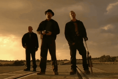 Three Men Standing Next To Each Other On A Road Holding Guns GIF