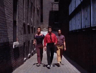 Three Men Walking Down Narrow Alleyway GIF