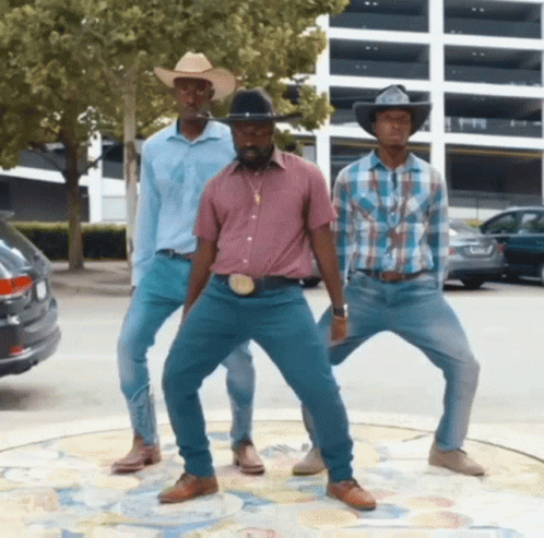 Three Men Wearing Cowboy Hats And Jeans Are Dancing In A Parking Lot GIF
