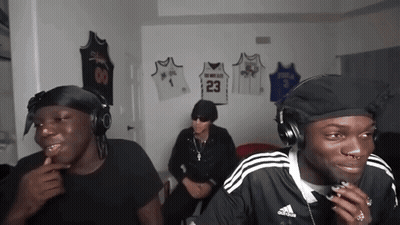 Three Men Wearing Headphones Are Sitting In A Room With Jerseys Hanging On The Wall Including One With The Number 23 On  GIF