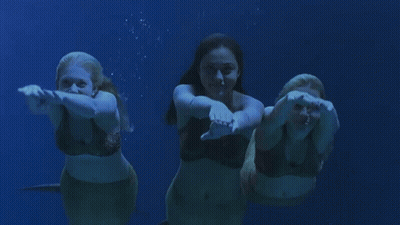 Three Mermaids Swimming In A Line GIF