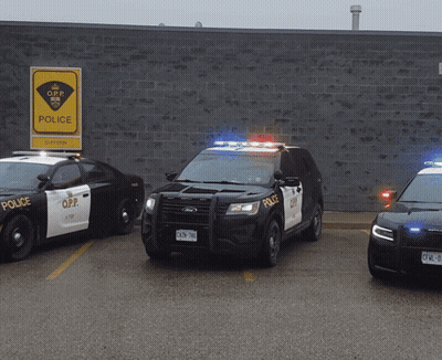 Three O.P.P. Police Cars Parked at Brick Building