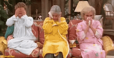 Three Older Women Are Sitting On A Couch Covering Their Eyes With Their Hands And Blowing Their Noses . GIF
