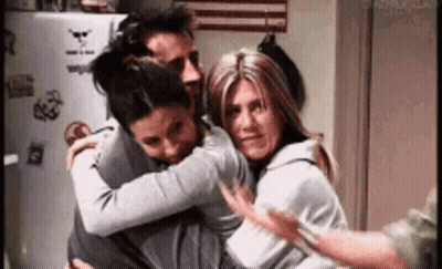 Three People Are Hugging Each Other In A Room . GIF
