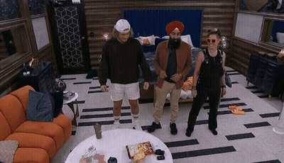 Three People Are Standing In A Room With A Couch And A Table GIF