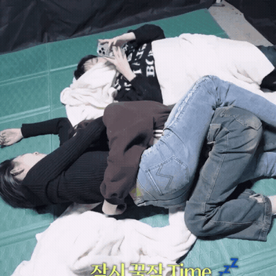 Three People Laying On Top Of Each Other On A Green Mat With The Word Time Written On The Bottom GIF