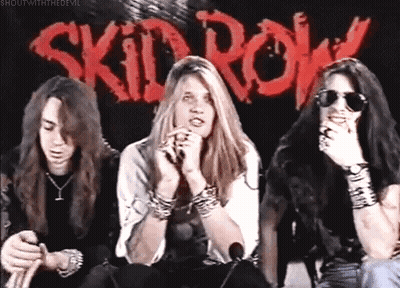 Three People Sitting Before Skid Row Sign GIF