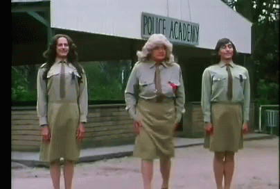 Three People Standing In Front Of A Police Academy Building GIF