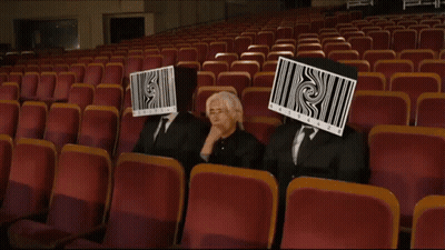 Three People With Barcodes On Face In Auditorium GIF