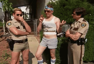 Three Police Officers Are Standing Next To Each Other On A Sidewalk Talking To A Man In Shorts . GIF