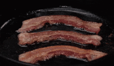 Three Slices Of Bacon Are Being Cooked In A Pan GIF