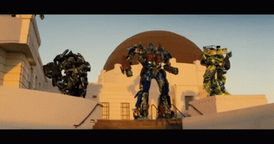 Three Transformers Standing In Front Of Dome GIF