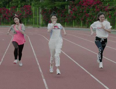 Three Women Are Running On A Track And One Of Them Is Wearing A White Shirt That Says Peace GIF