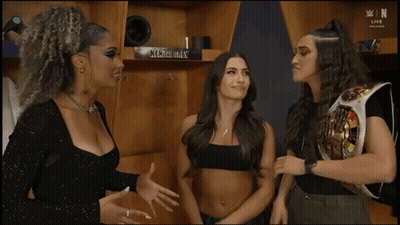 Three Women Are Standing Next To Each Other In A Room . GIF