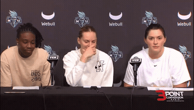Three Women at Table in Front of Webull Sign