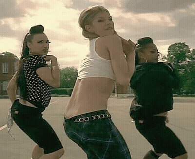 Three Women Dancing In Parking Lot, One Belt Says XXX GIF