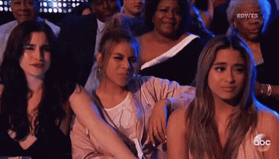 Three Women In Crowd, One Hugging Another GIF