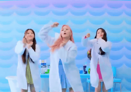 Three Women In Lab Coats Are Dancing In Front Of A Blue Background GIF