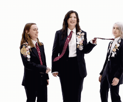 Three Women In Suits And Ties With Pins GIF