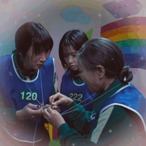 Three Women Wearing Blue Vests With Numbers 120 And 222 On Them GIF