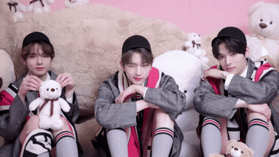 Three Young Men Are Sitting Next To Each Other Holding Stuffed Animals GIF
