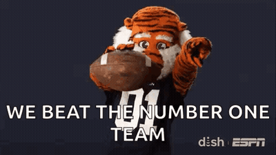 Tiger Mascot Holding Football Saying We Beat the Number One Team
