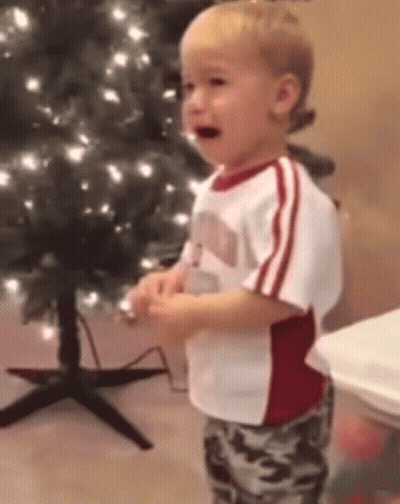 Toddler Crying In Front Of Christmas Tree GIF