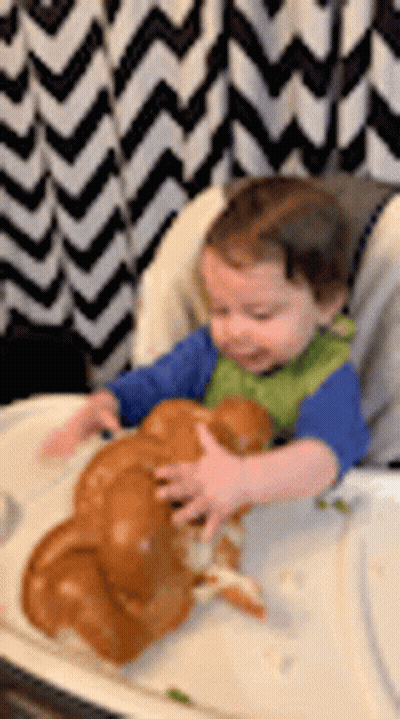 Toddler In High Chair Playing With Bread GIF
