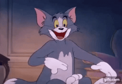 Tom From The Cartoon Tom And Jerry Is Sitting On The Floor With His Mouth Open . GIF