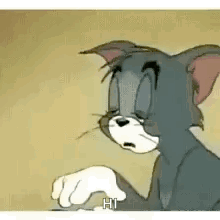 Tom From Tom And Jerry Is Sitting Down With His Eyes Closed And A Hand In His Mouth . GIF