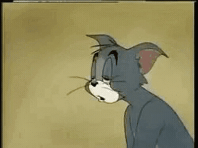 Tom From Tom And Jerry Is Sitting Down With His Eyes Closed And A Sad Look On His Face . GIF