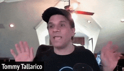 Tommy Tallarico Is Wearing A Black Shirt And A Baseball Cap GIF