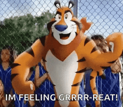 Tony The Tiger Standing In Front Of Chain Link Fence With People Behind GIF