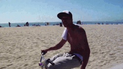 Topless Man Riding Bike By The Beach GIF