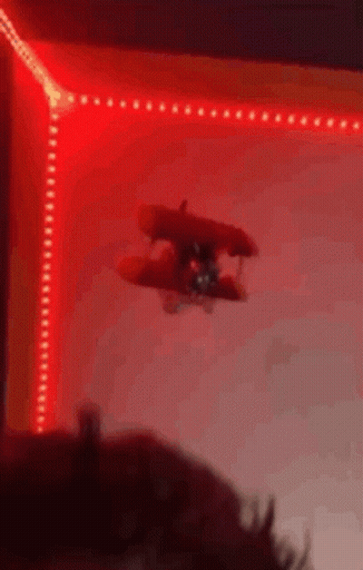Toy Airplane Flying Through Red Light GIF