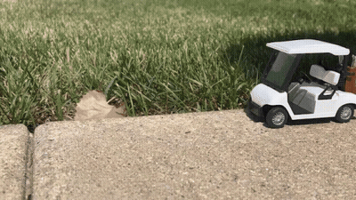 Toy Golf Cart On Sidewalk By Golf Course GIF