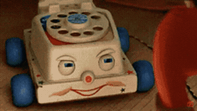 Toy Telephone With Face Next To Red Telephone GIF