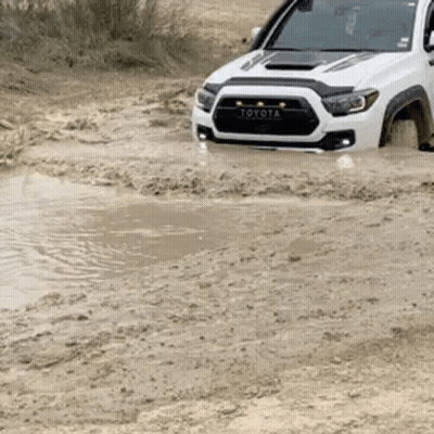 Toyota Tacoma Driving Through Muddy Puddle GIF