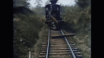 Train Approaching Wood On Tracks GIF