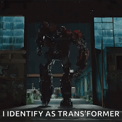 Transformer Robot Standing In Dark Room Says I Identify As Transformer GIF
