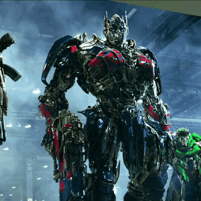 Transformer Standing In Front Of Sign Saying V32 GIF