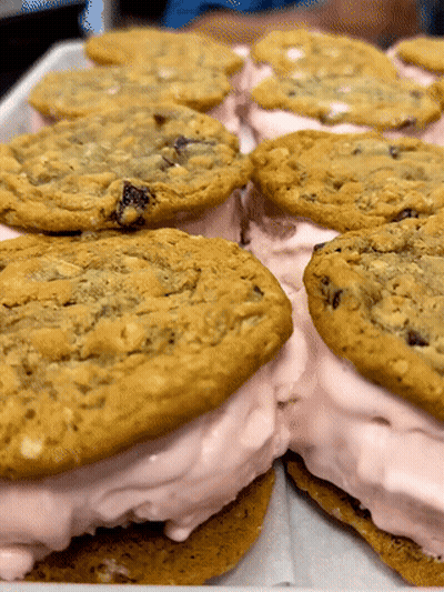 Tray Of Ice Cream Sandwiches With Chocolate Chip Cookies And Pink Frosting GIF