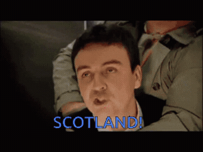 Trench Coat Man Held By Another Saying Scotland GIF