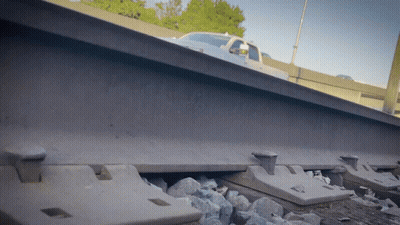 Truck Driving Down Train Tracks With Water Bottle GIF