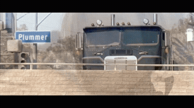Truck Driving Next To Plummer Street Sign GIF
